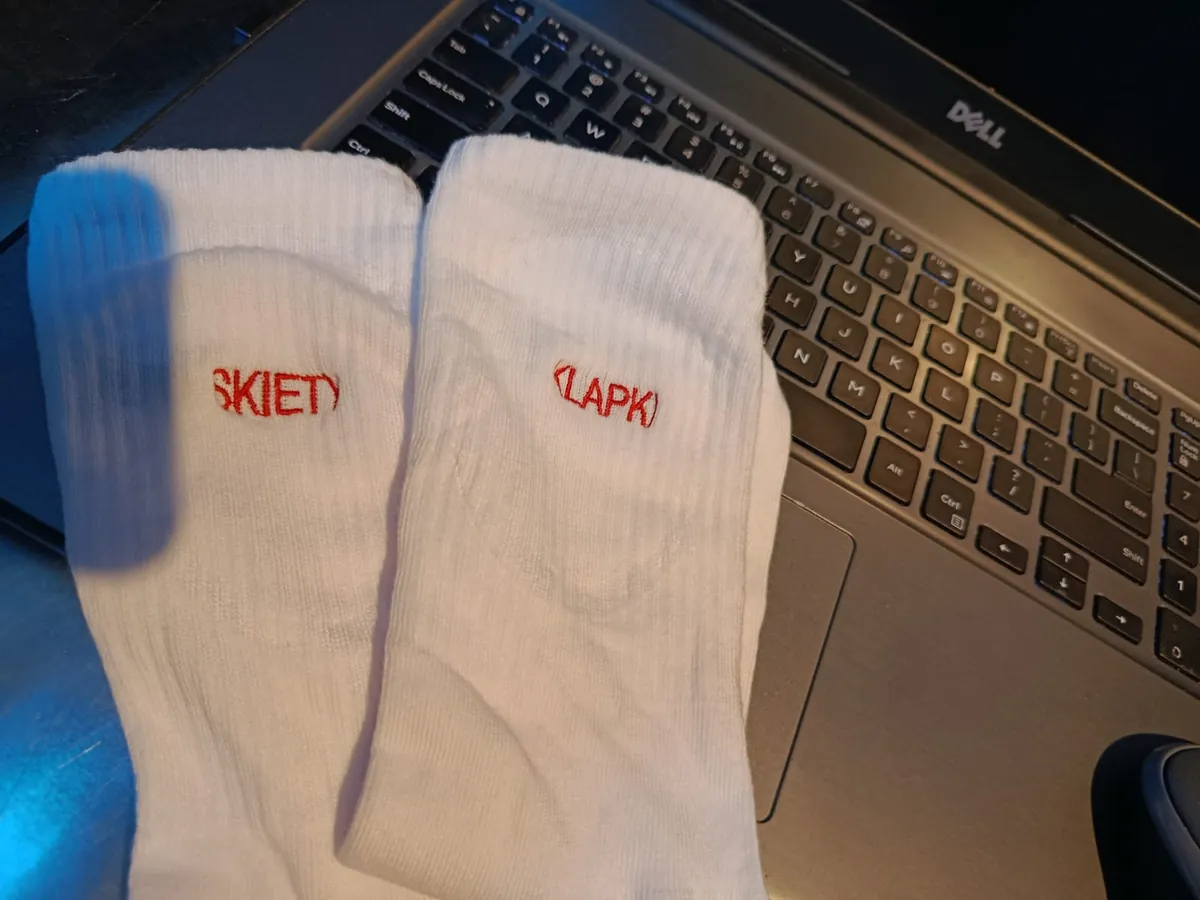 Detal personalizowanych skarpet z czerwonym haftem